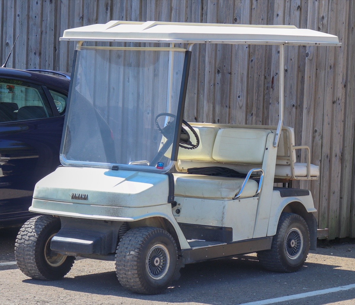 A Yamaha golf cart parked on grass at an outdoor rally