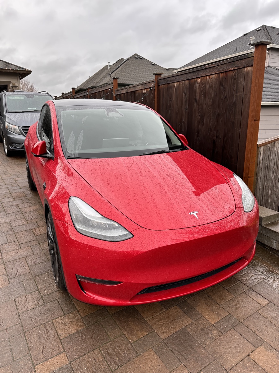 Red Tesla Model Y with ceramic window tint applied to its side and rear windows.